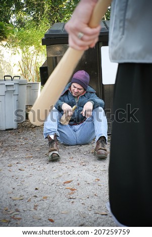 stock-photo-young-thug-with-baseball-bat-about-to-attack-a-homeless-man-207259759.jpg